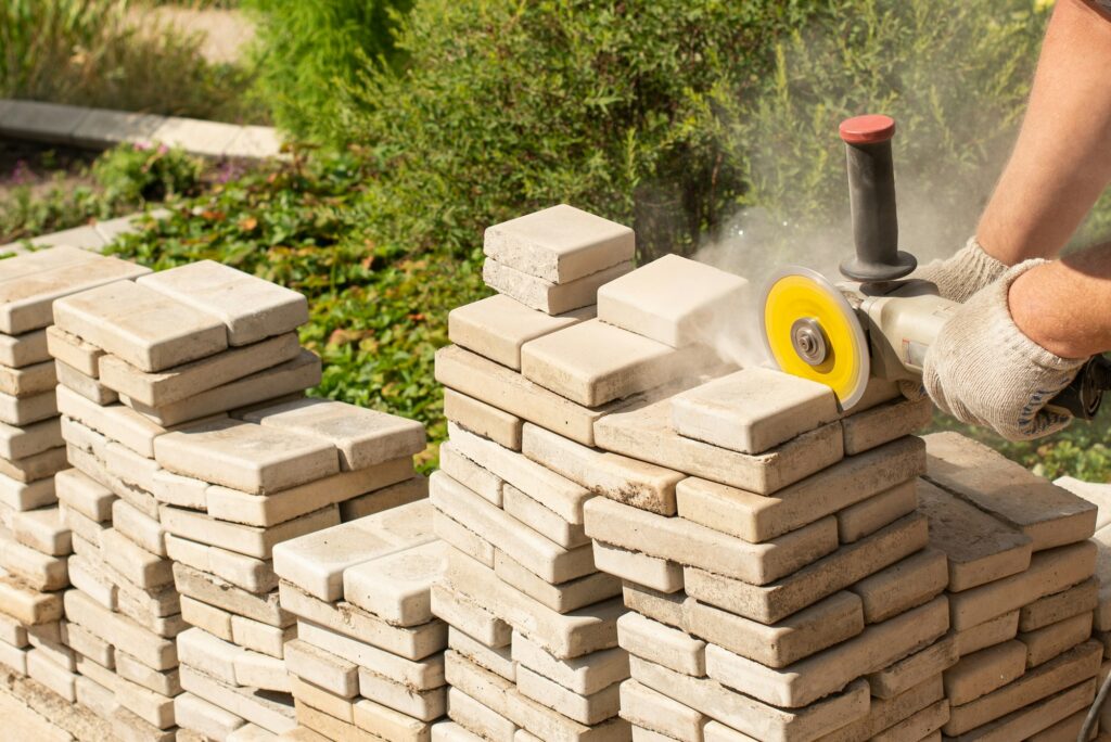 Master saws paving slabs with a grinder grinder. Dust